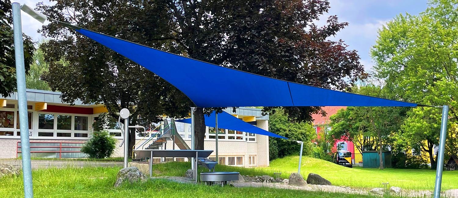 Vela ombreggiante fissa blu nel cortile di una scuola
